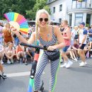 woman in black and white polka dot bikini top and black sunglasses holding multicolored umbrella