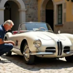 Mécanicien inspectant la carrosserie d'une BMW 507 vintage ivoire sur des pavés bavarois avant achat