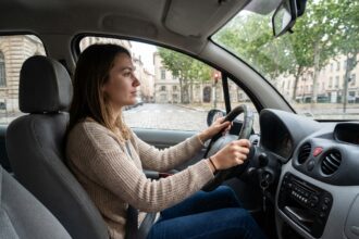 Jeune femme au volant d'une voiture à Lyon
