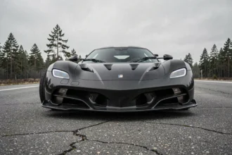 Koenigsegg Agera R noir carbone garé sur route ouverte avec paysage scandinave en arrière-plan