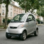 Voiture sans permis d'occasion en stationnement dans une rue résidentielle française, modèle compact à petit prix