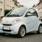 Voiture sans permis compacte garée dans une rue résidentielle française, vue trois quarts avant